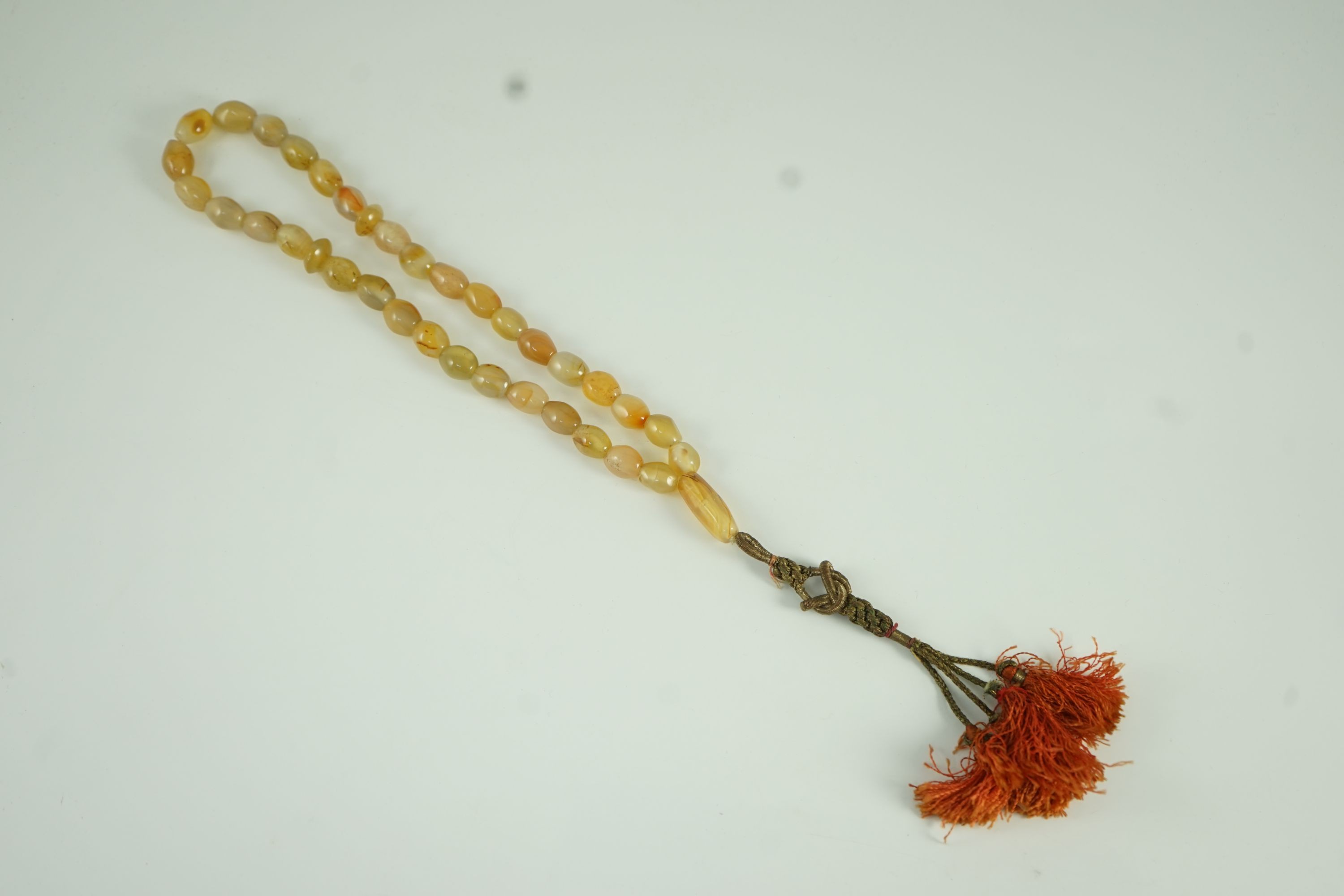 A Sino-Tibetan row of agate prayer beads, 19th century Total drop including tassel 36 cm